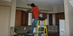 Technician Cleaning Mold Off of Ceiling After Ceiling Leak