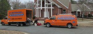 Water Damage Restoration Van And Truck Parked At Residential Job Site